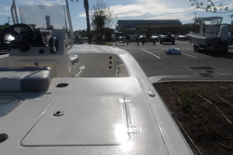 Slide: The Image of 2026 Mako 18 Pro Skiff boat in parking lot, showcasing deck and steering console. - 10