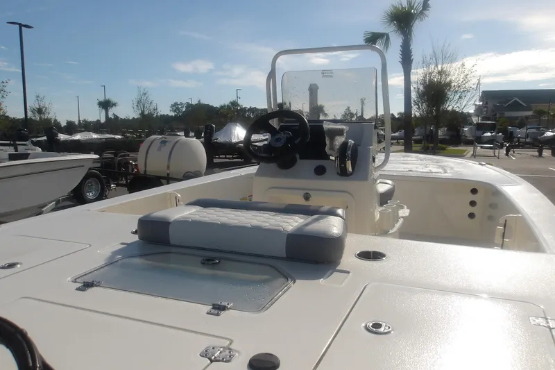 Slide: The Image of 2026 Mako 18 Pro Skiff boat with center console and seating, parked outdoors. - 9