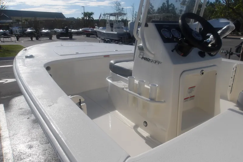 Slide: The Image of 2026 Mako 18 Pro Skiff boat interior with steering console and rod holders. - 13