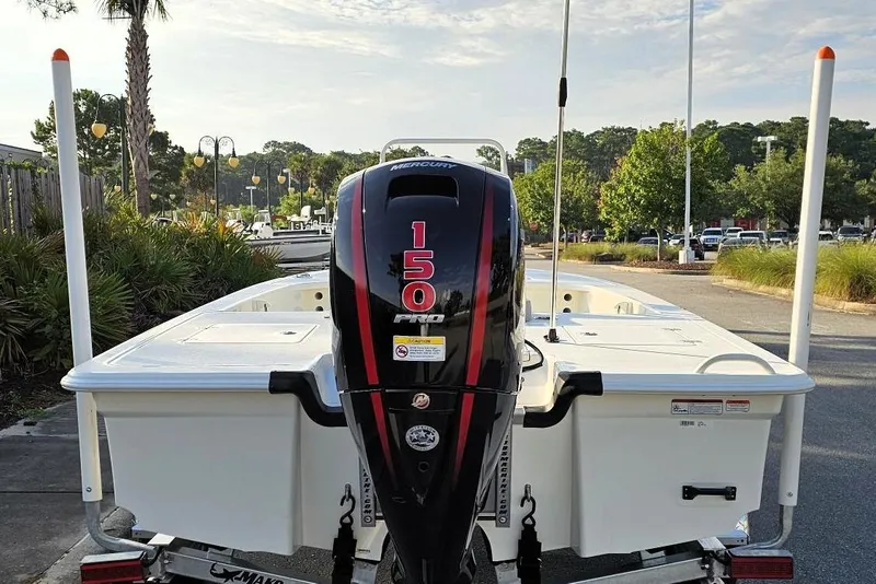 Slide: The Image of 2026 Mako 18 Pro Skiff with Mercury 150 Pro outboard engine, parked outdoors. - 10