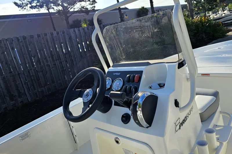 Slide: The Image of 2026 Mako 18 Pro Skiff boat console with steering wheel and gauges. - 11