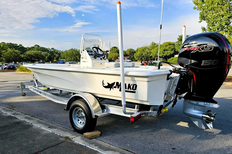 Slide: The Image of 2026 Mako 18 Pro Skiff boat on trailer with Mercury 150 engine in parking lot. - 8