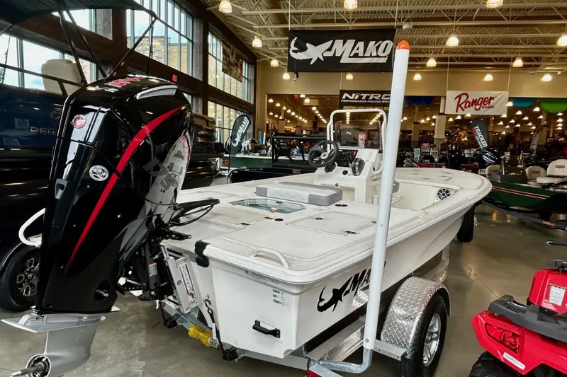 Slide: The Image of 2026 Mako Pro Skiff 18 boat on display in showroom with trailer. - 2