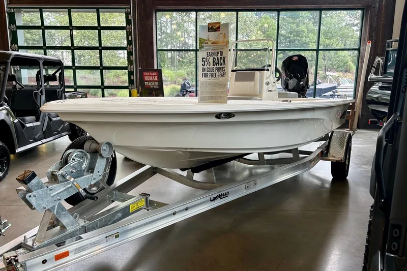 Slide: The Image of 2026 Mako Pro Skiff 18 boat displayed indoors with powerful outboard motor. - 3