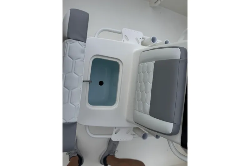 Slide: The Image of 2026 Mako 18 Pro Skiff interior with cushioned seating and storage compartment. - 16