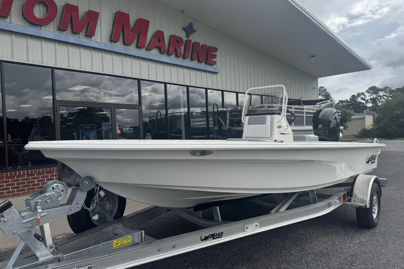 Slide: The Image of 2026 Mako 18 Pro Skiff boat on trailer outside marine dealership. - 7