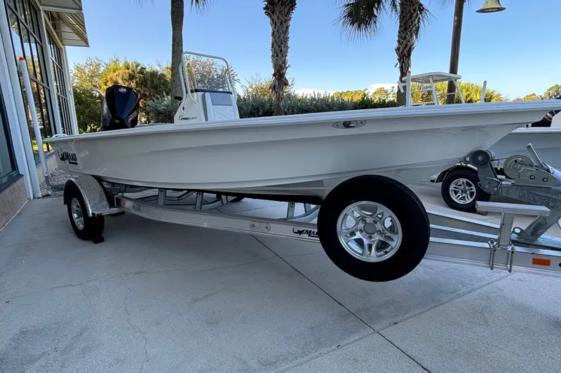The Image of 2026 Mako 18 Pro Skiff boat on trailer, parked outdoors near palm trees. - 0