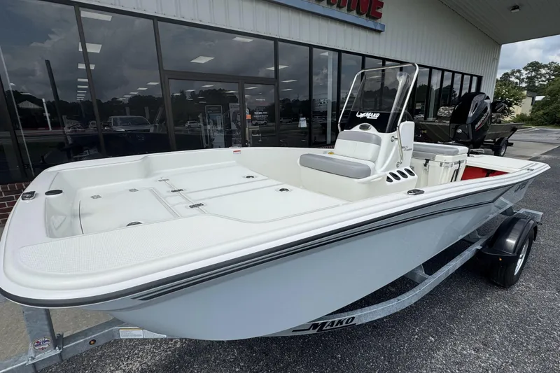 Slide: The Image of 2026 Mako Pro Skiff 15 CC boat displayed outside a showroom. - 12