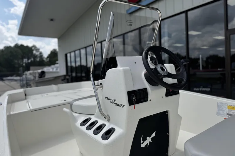 Slide: The Image of 2026 Mako Pro Skiff 15 CC boat console with steering wheel and rod holders. - 6