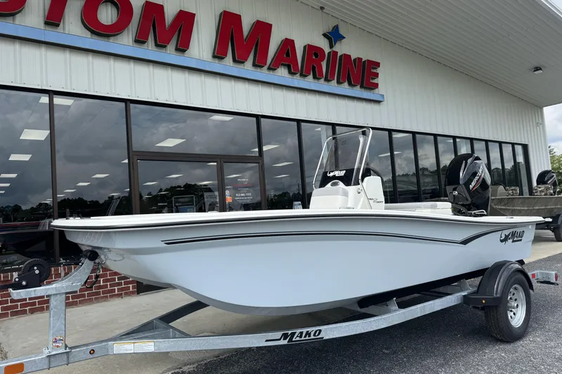 Slide: The Image of 2026 Mako Pro Skiff 15 CC boat on trailer outside marine store. - 8