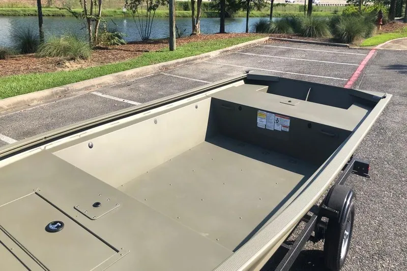 Slide: The Image of 2026 Tracker Grizzly 1648 Utility boat in parking lot near a pond. - 7