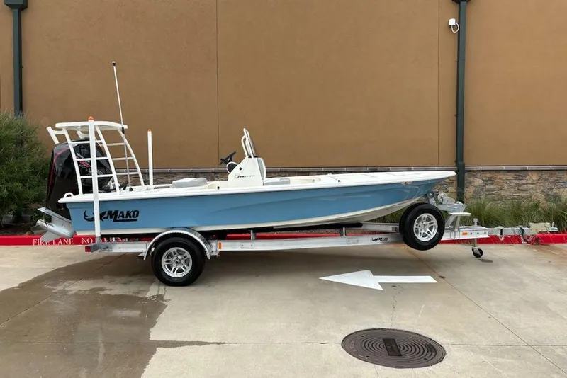 Slide: The Image of 2026 Mako 18 Pro Skiff boat on trailer, parked outdoors. - 2