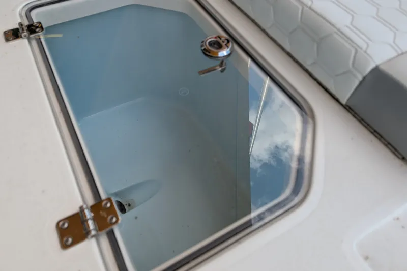 Slide: The Image of Livewell compartment on 2026 Mako 18 Pro Skiff boat, featuring secure latch and clear lid. - 11