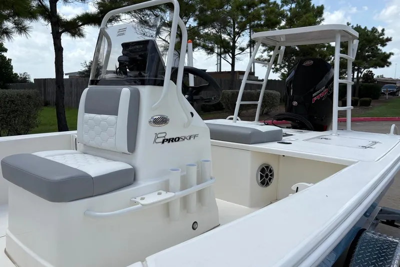 Slide: The Image of 2026 Mako 18 Pro Skiff boat with seating and console, parked outdoors. - 5