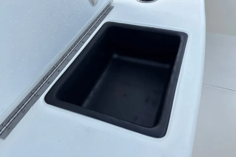 Slide: The Image of Storage compartment on a 2026 Mako 18 Pro Skiff boat, featuring a black interior. - 19