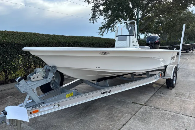 Slide: The Image of 2026 Mako 18 Pro Skiff boat on trailer, parked outdoors. - 1