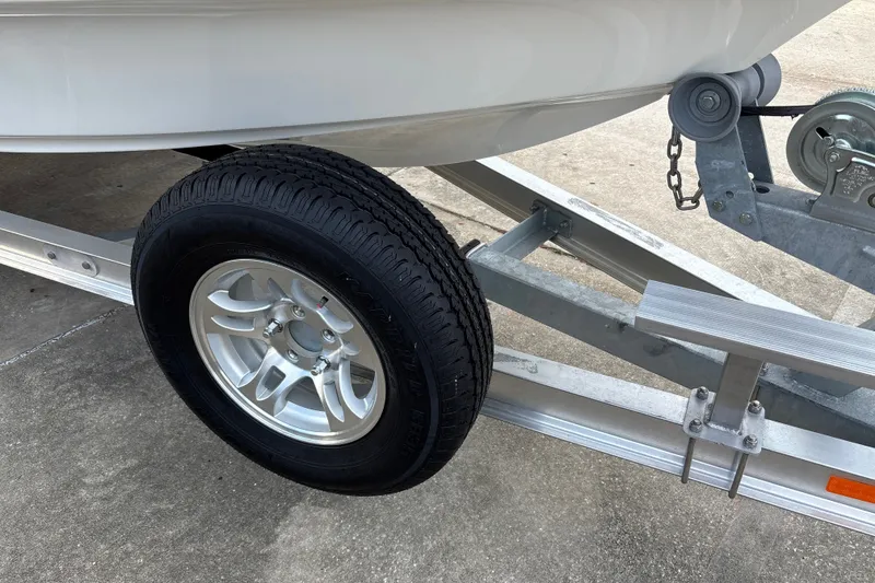 Slide: The Image of Trailer wheel and hitch of 2026 Mako 18 Pro Skiff boat on concrete surface. - 21