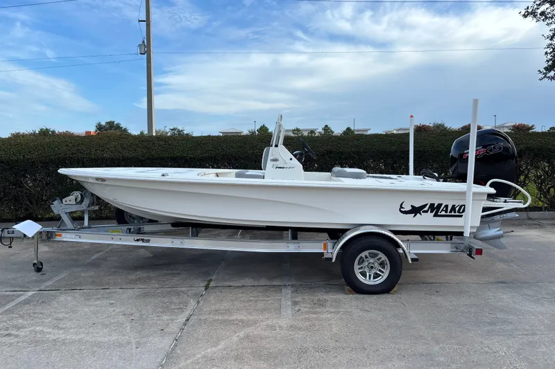 The Image of 2026 Mako 18 Pro Skiff boat on trailer, parked outdoors under a clear sky. - 0