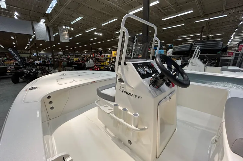 Slide: The Image of 2026 Mako 18 Pro Skiff boat interior with steering console in showroom. - 4