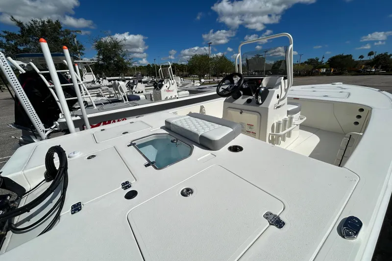 Slide: The Image of 2026 Mako 18 Pro Skiff boat with console and seating, parked outdoors under blue sky. - 4