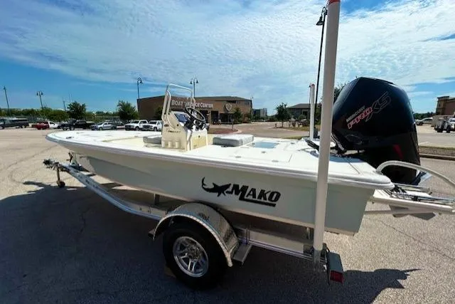 Slide: The Image of 2026 Mako 18 Pro Skiff boat on trailer, parked outdoors under a clear sky. - 3