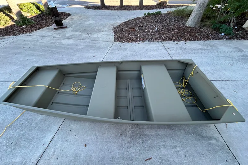 Slide: The Image of 2026 Tracker Grizzly 10 Jon boat on concrete, with yellow ropes attached. - 2