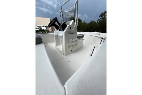 Slide: The Image of 2026 Mako 18 Pro Skiff boat interior with steering console, white deck, and overcast sky. - 8