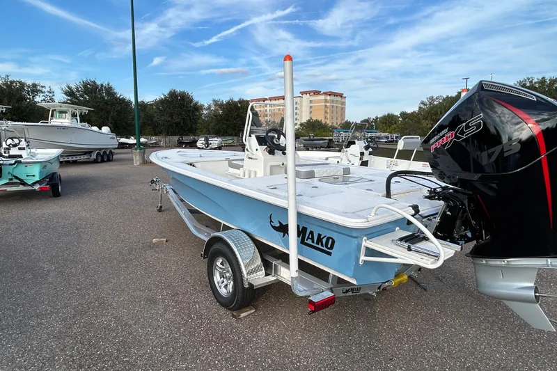 Slide: The Image of 2026 Mako 18 Pro Skiff boat with Mercury engine on trailer in parking lot. - 2