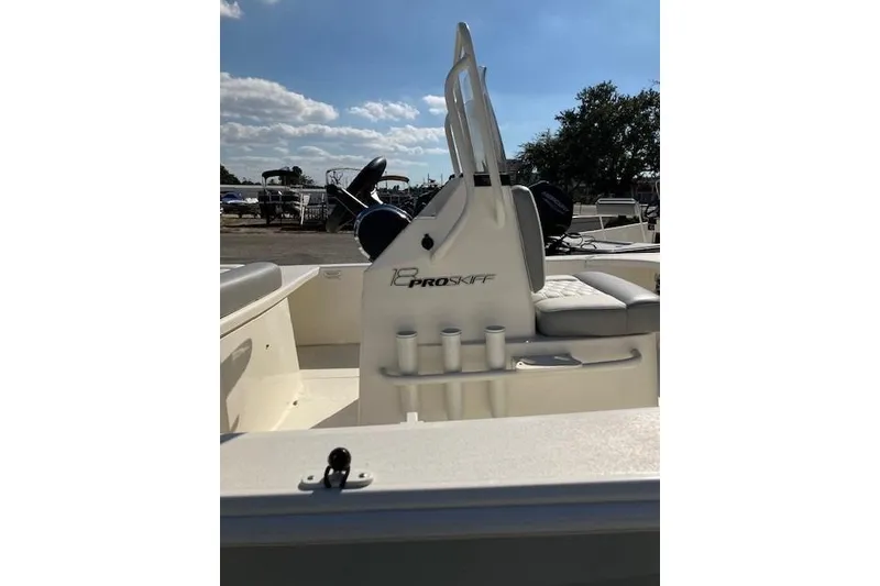 Slide: The Image of 2026 Mako 18 Pro Skiff boat interior with seating and rod holders under a clear sky. - 4