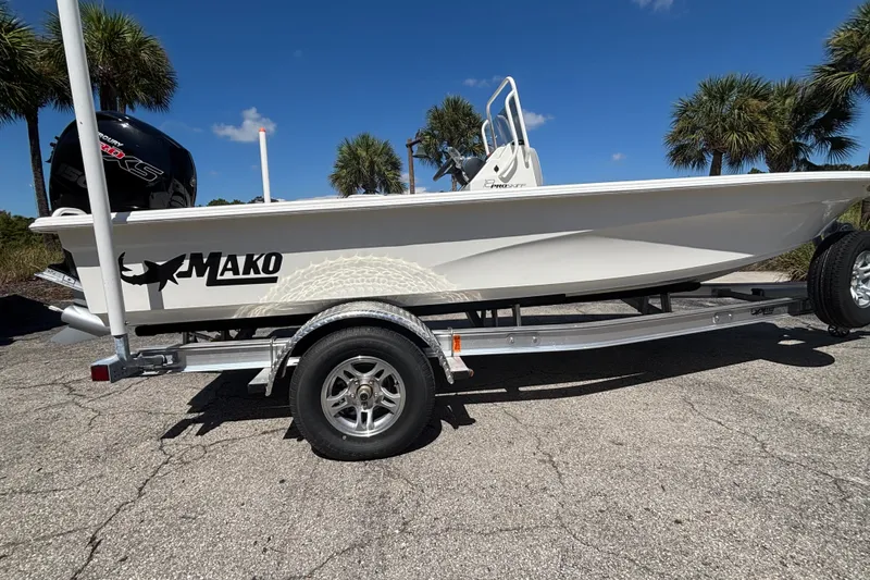 The Image of 2026 Mako 18 Pro Skiff boat on trailer, parked outdoors under clear blue sky. - 0