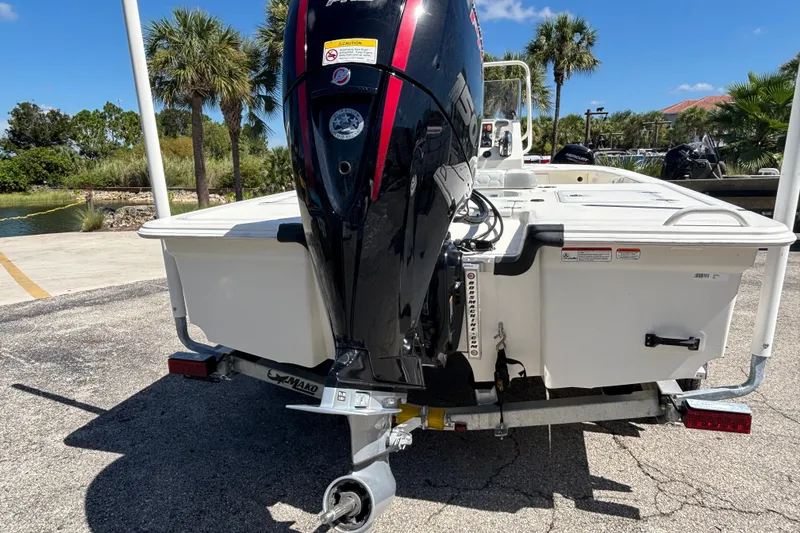 Slide: The Image of 2026 Mako 18 Pro Skiff boat with powerful outboard motor, parked on a sunny day. - 2
