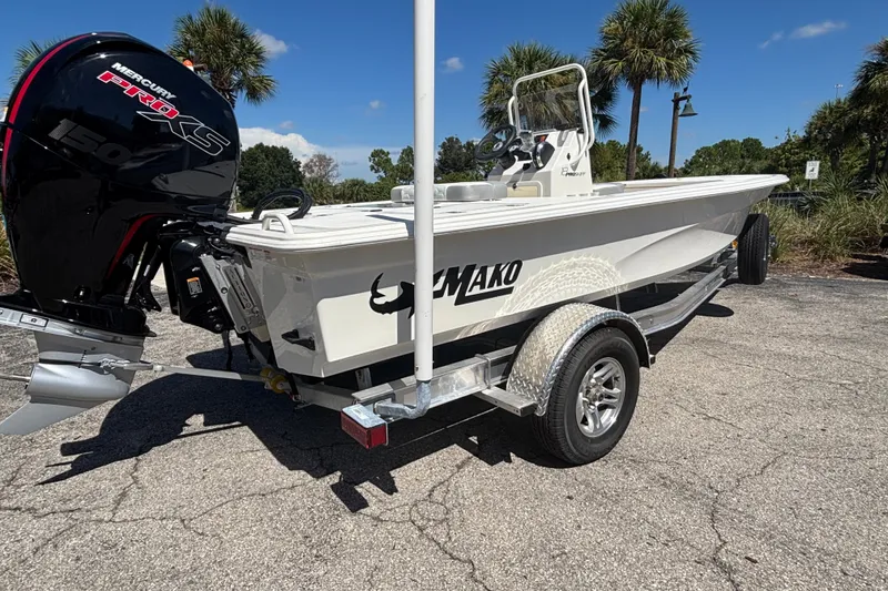 Slide: The Image of 2026 Mako 18 Pro Skiff boat on trailer with Mercury engine, parked outdoors. - 1
