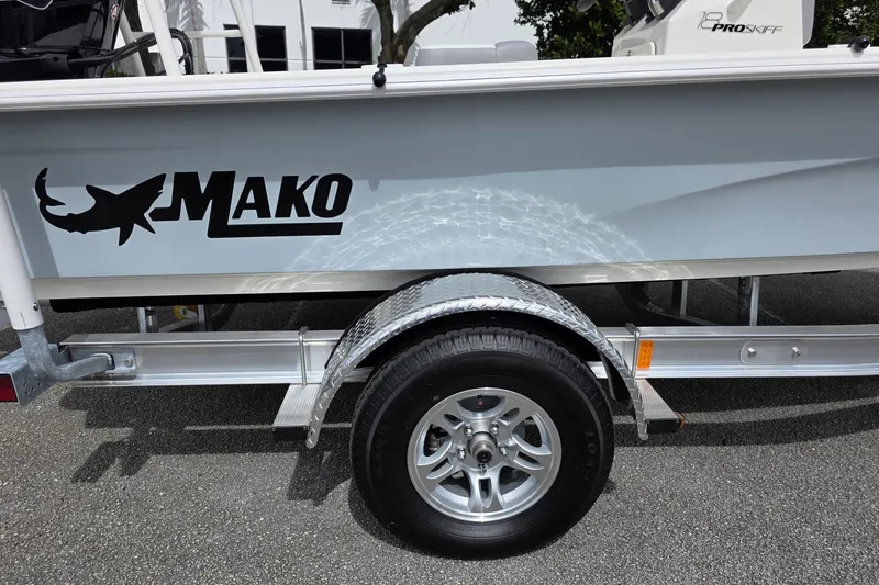 Slide: The Image of 2026 Mako 18 Pro Skiff boat on trailer, showcasing logo and wheel detail. - 12
