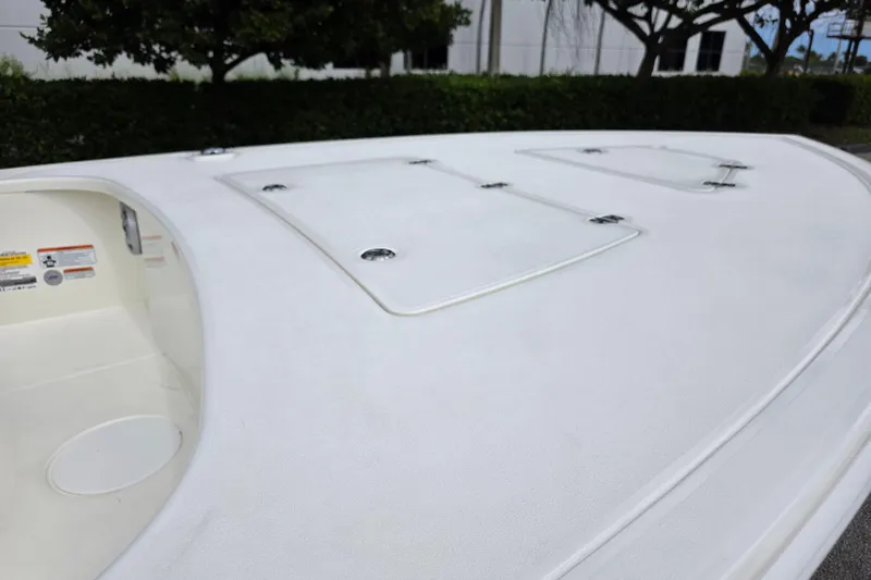 Slide: The Image of 2026 Mako 18 Pro Skiff boat deck with storage compartments, outdoor setting. - 7