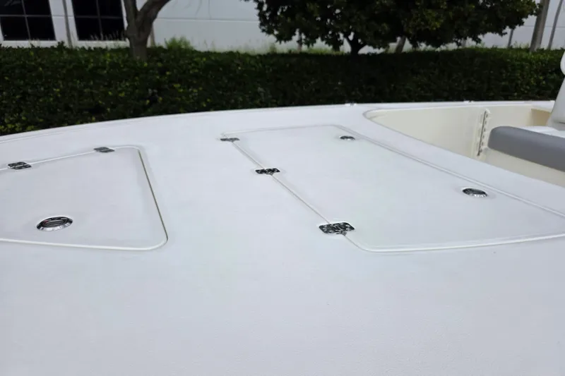 Slide: The Image of 2026 Mako 18 Pro Skiff deck with storage hatches, outdoor setting. - 9