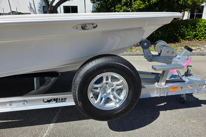 Slide: The Image of 2026 Mako 18 Pro Skiff on trailer, showcasing wheel and hull details. - 13