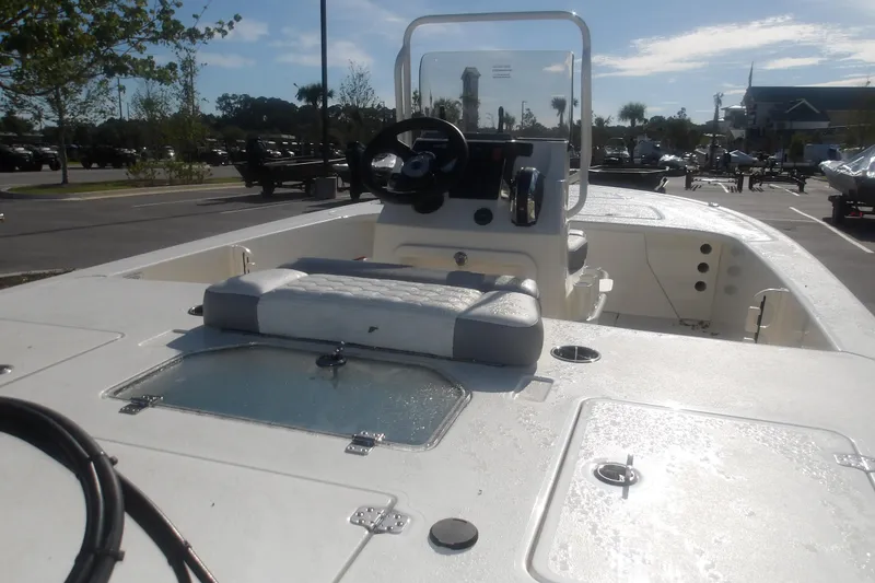 Slide: The Image of 2026 Mako 18 Pro Skiff boat interior with steering console and seating in a parking lot. - 21