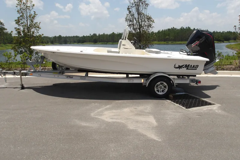 The Image of 2026 Mako 18 Pro Skiff on trailer by a scenic lake. - 1
