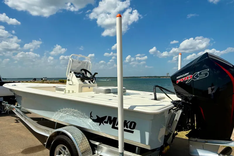 Slide: The Image of 2026 Mako 18 Pro Skiff boat with Mercury engine by the water. - 15