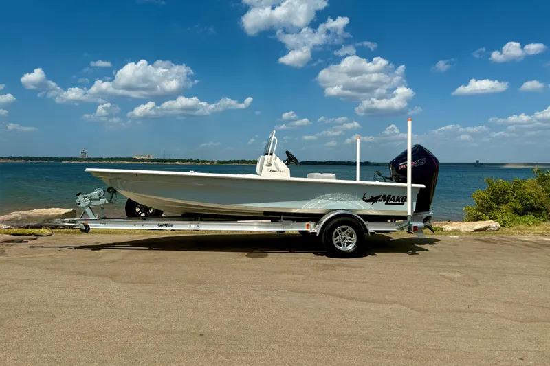 Slide: The Image of 2026 Mako 18 Pro Skiff on trailer by a scenic lake under a blue sky. - 14