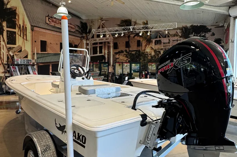 Slide: The Image of 2026 Mako 18 Pro Skiff boat with Mercury Pro XS engine in showroom. - 1