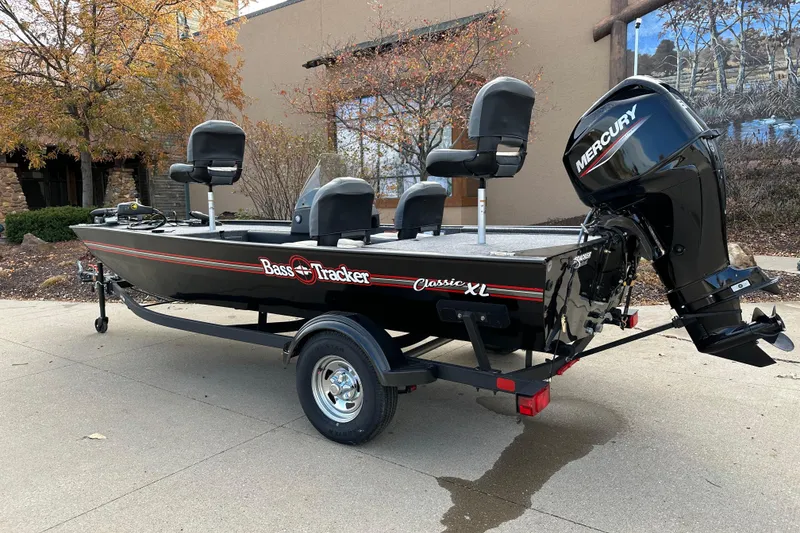 Slide: The Image of 2026 Tracker Bass Tracker Classic XL boat with Mercury engine, parked outdoors. - 2