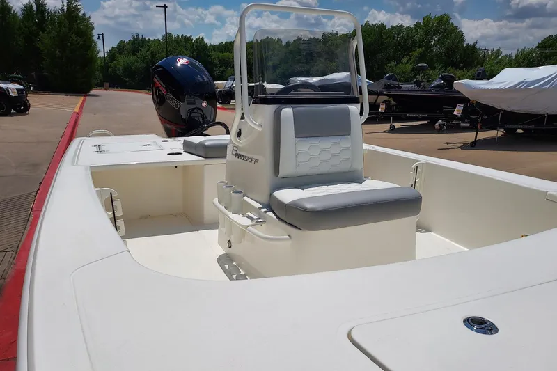 Slide: The Image of 2026 Mako Pro Skiff 18 boat with center console and outboard motor in a marina setting. - 1