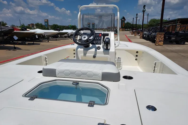 Slide: The Image of 2026 Mako Pro Skiff 18 boat with console and seating, displayed outdoors under a clear sky. - 3