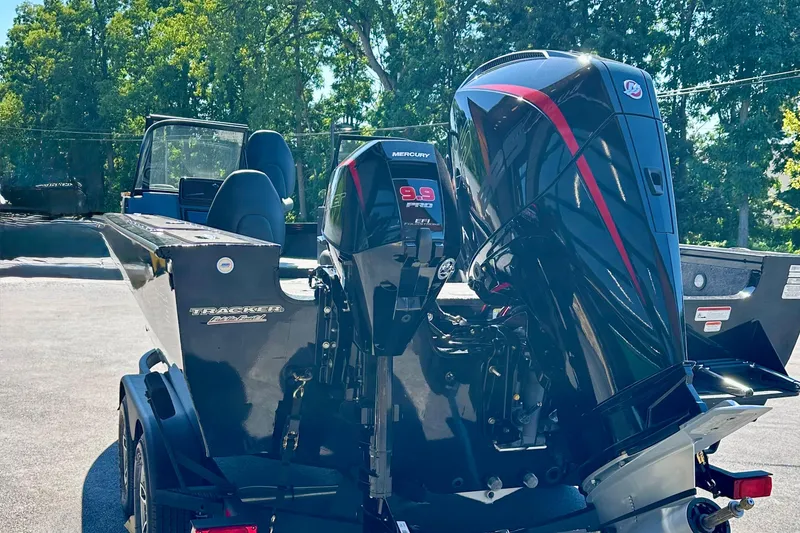 Slide: The Image of 2026 Tracker Targa V-19 WT boat with dual Mercury engines, parked outdoors. - 4
