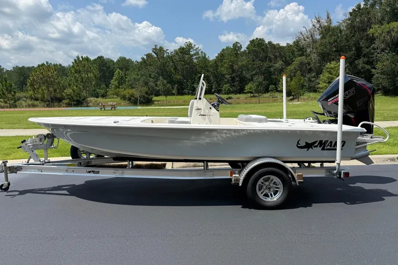 The Image of 2026 Mako Pro Skiff 18 boat on trailer, parked outdoors under a cloudy sky. - 0