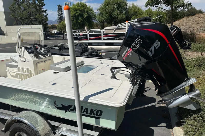 Slide: The Image of 2026 Mako Pro Skiff 18 boat with Mercury 175 engine, parked outdoors. - 2
