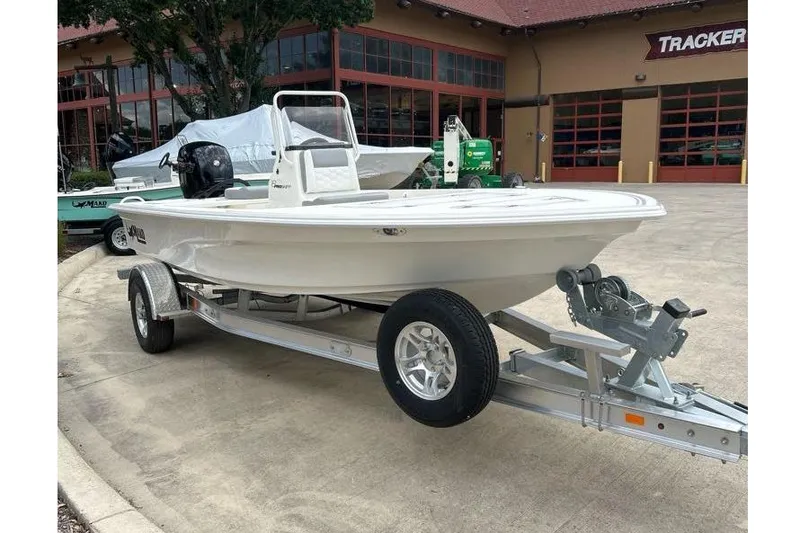 Slide: The Image of 2026 Mako Pro Skiff 18 boat on trailer, parked outside a dealership. - 56