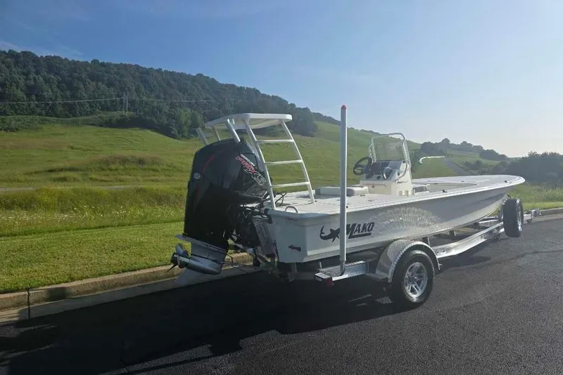 Slide: The Image of 2026 Mako 18 Pro Skiff boat on trailer, parked on a scenic road. - 4