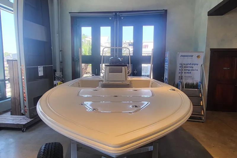 Slide: The Image of 2026 Mako Pro Skiff 18 boat displayed indoors, showcasing sleek design and spacious deck. - 1